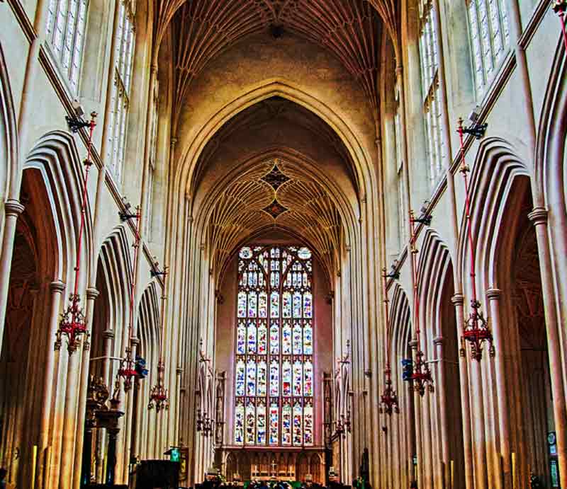 Large stained glass window and vaulted ceiling.