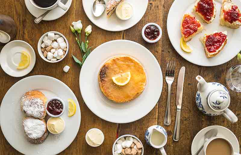 Variety of dishes and beverages including a Sally Lunn bun.