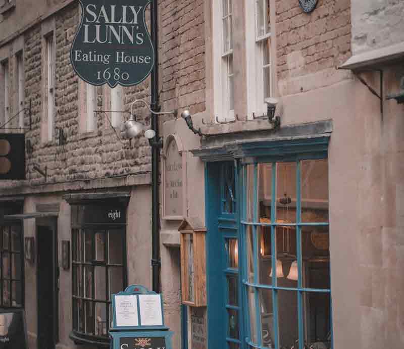 Shop frontage with blue-painted bow panelled window and sign with date 1680.